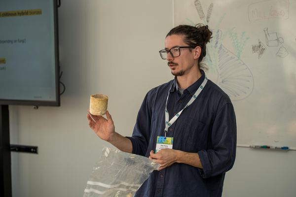 Peter Petros presenting a cylindrical mycelium material sample during the RRR2025 workshop