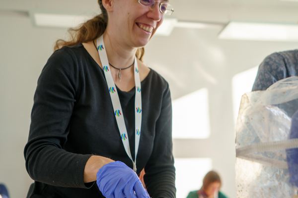 Workshop participant examining a sample beside mycelium materials