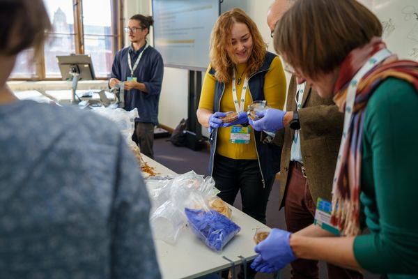 Participants examining petri dishes and material samples during the workshop